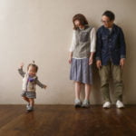 よちよち歩きの１才女の子と優しく見守る両親