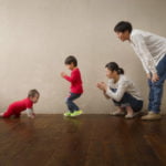 ハイハイをする１才男の子を応援する家族